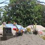 im Friedhof sieht man die aufgeschütteten, zum Teil bunt geschmückten Gräber<br />					